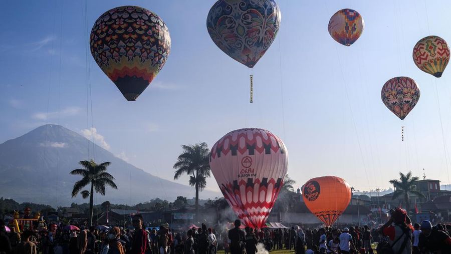 WONOSOBO, INDONESIA - APRIL 23: Hot air balloons fly over the sky during a balloon festival on the Eid al-Fitr holiday at Ronggolawe Stadion on April 23, 2023, in Wonosobo, Central Java, Indonesia. Javanese people fly giant hot air balloons during Eid, which has long been a tradition of the Wonosobo regency. (Photo by Garry Lotulung/Anadolu Agency via Getty Images)