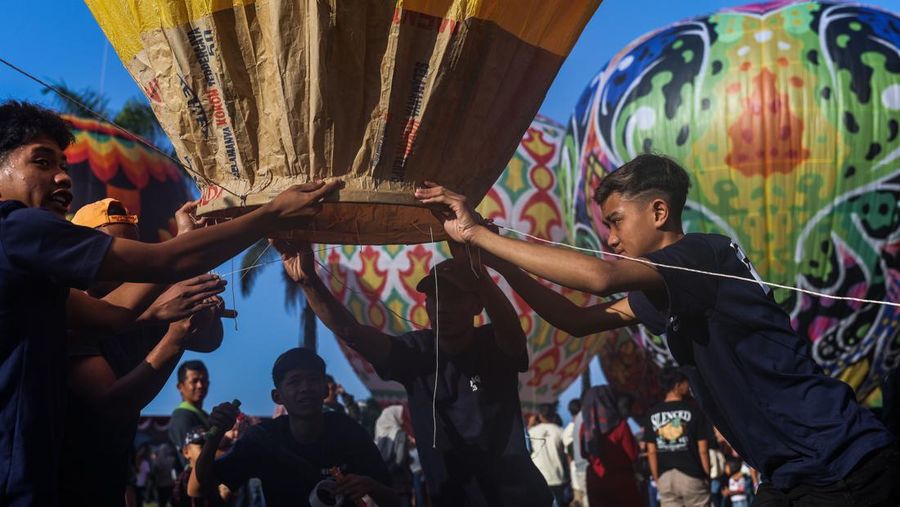 WONOSOBO, INDONESIA - APRIL 23: Participants prepare balloons to fly during a balloon festival on the Eid al-Fitr holiday at Ronggolawe Stadion on April 23, 2023, in Wonosobo, Central Java, Indonesia. Javanese people fly giant hot air balloons during Eid, which has long been a tradition of the Wonosobo regency. (Photo by Garry Lotulung/Anadolu Agency via Getty Images)