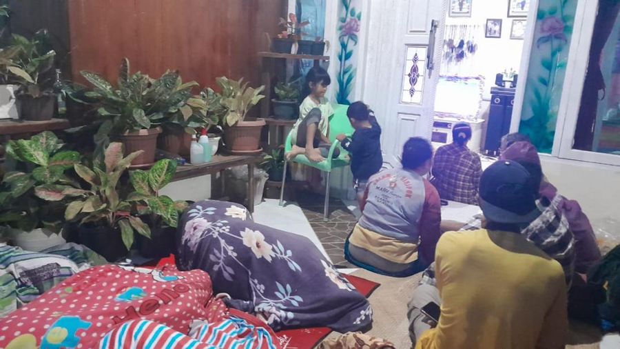 Warga berada di luar rumah dan rumah sakit setelah gempa bermagnitudo 7,1 terjadi di wilayah mereka di Desa Muara Sikabaluan, Pulau Siberut pada 25 April 2023. (BAMBANG SAGURUNG/AFP via Getty Images)