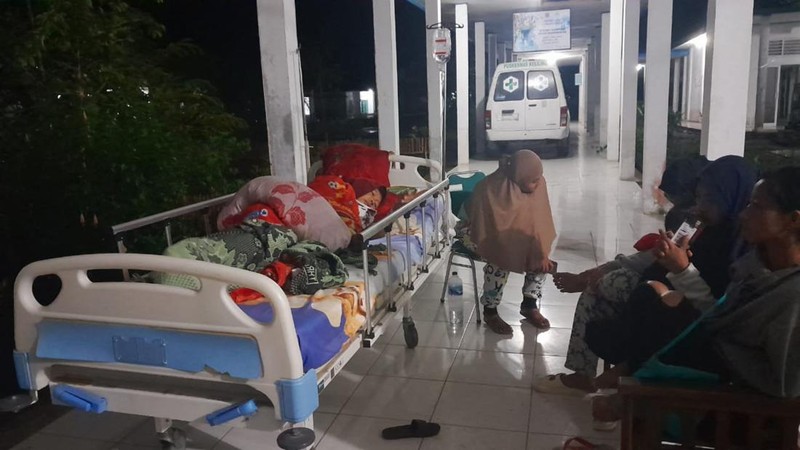 Warga berada di luar rumah dan rumah sakit setelah gempa bermagnitudo 7,1 terjadi di wilayah mereka di Desa Muara Sikabaluan, Pulau Siberut pada 25 April 2023. (BAMBANG SAGURUNG/AFP via Getty Images)