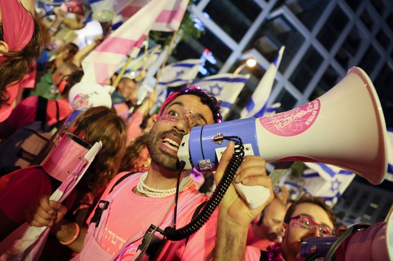 Demonstran menyalakan suar selama unjuk rasa di Tel Aviv untuk memprotes RUU perbaikan peradilan pemerintah Israel, saat negara itu memulai perayaan ulang tahun ke-75, pada 25 April 2023. (JACK GUEZ/AFP via Getty Images)