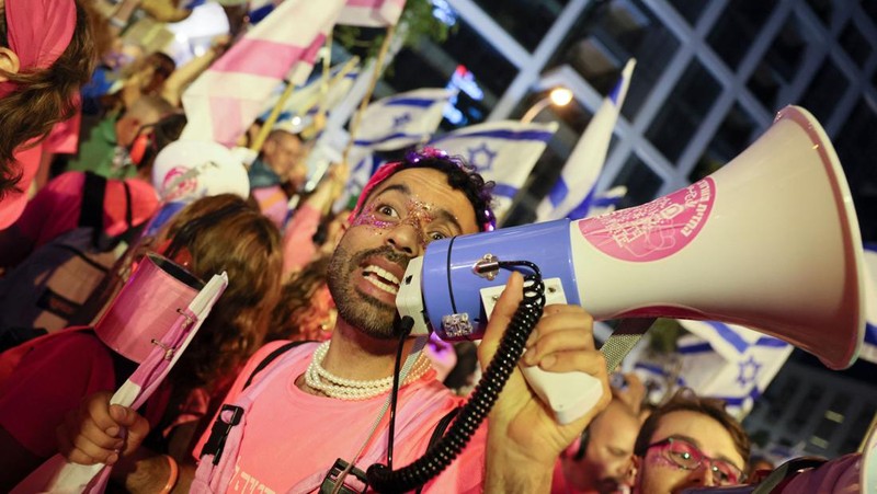 Demonstran menyalakan suar selama unjuk rasa di Tel Aviv untuk memprotes RUU perbaikan peradilan pemerintah Israel, saat negara itu memulai perayaan ulang tahun ke-75, pada 25 April 2023. (JACK GUEZ/AFP via Getty Images)