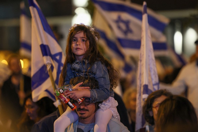 Demonstran menyalakan suar selama unjuk rasa di Tel Aviv untuk memprotes RUU perbaikan peradilan pemerintah Israel, saat negara itu memulai perayaan ulang tahun ke-75, pada 25 April 2023. (JACK GUEZ/AFP via Getty Images)