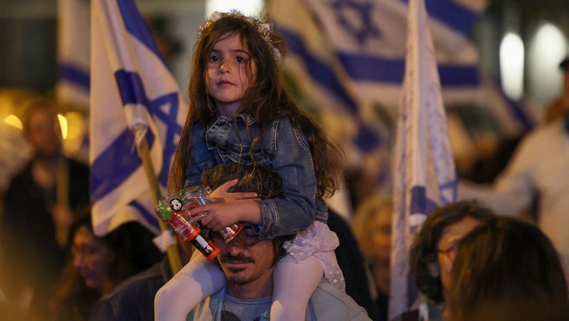 Demonstran menyalakan suar selama unjuk rasa di Tel Aviv untuk memprotes RUU perbaikan peradilan pemerintah Israel, saat negara itu memulai perayaan ulang tahun ke-75, pada 25 April 2023. (JACK GUEZ/AFP via Getty Images)