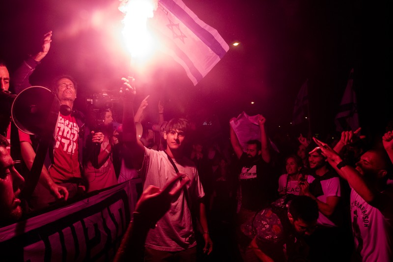 Demonstran menyalakan suar selama unjuk rasa di Tel Aviv untuk memprotes RUU perbaikan peradilan pemerintah Israel, saat negara itu memulai perayaan ulang tahun ke-75, pada 25 April 2023. Demonstran menyalakan suar selama unjuk rasa di Tel Aviv untuk memprotes RUU perbaikan peradilan pemerintah Israel, saat negara itu memulai perayaan ulang tahun ke-75, pada 25 April 2023. (JACK GUEZ/AFP via Getty Images)
