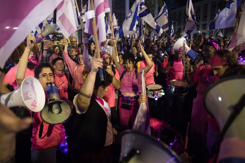 Demonstran menyalakan suar selama unjuk rasa di Tel Aviv untuk memprotes RUU perbaikan peradilan pemerintah Israel, saat negara itu memulai perayaan ulang tahun ke-75, pada 25 April 2023. (JACK GUEZ/AFP via Getty Images)