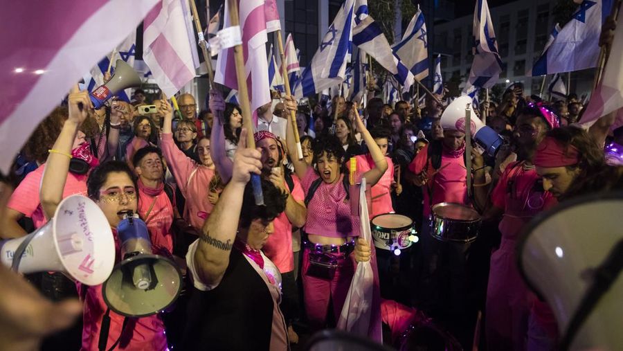 Demonstran menyalakan suar selama unjuk rasa di Tel Aviv untuk memprotes RUU perbaikan peradilan pemerintah Israel, saat negara itu memulai perayaan ulang tahun ke-75, pada 25 April 2023. (JACK GUEZ/AFP via Getty Images)