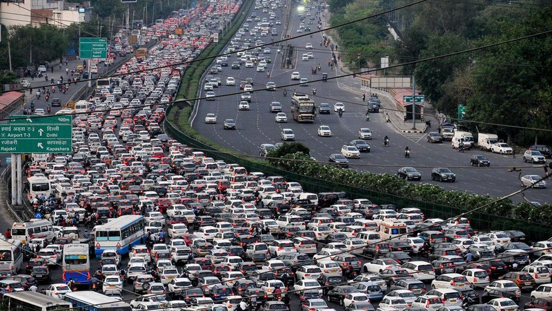 Orang-orang mengunjungi Gerbang India di New Delhi. - Setiap pagi dan sore dan selama beberapa jam di antara puluhan juta orang India duduk menganggur di jalan raya yang macet dan bergelantungan di sisi kereta penumpang yang padat di tempat yang menjadi negara terpadat di dunia. (Sajjad HUSSAIN / AFP)