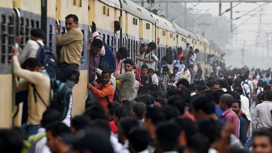 Orang-orang mengunjungi Gerbang India di New Delhi. - Setiap pagi dan sore dan selama beberapa jam di antara puluhan juta orang India duduk menganggur di jalan raya yang macet dan bergelantungan di sisi kereta penumpang yang padat di tempat yang menjadi negara terpadat di dunia. (Sajjad HUSSAIN / AFP)