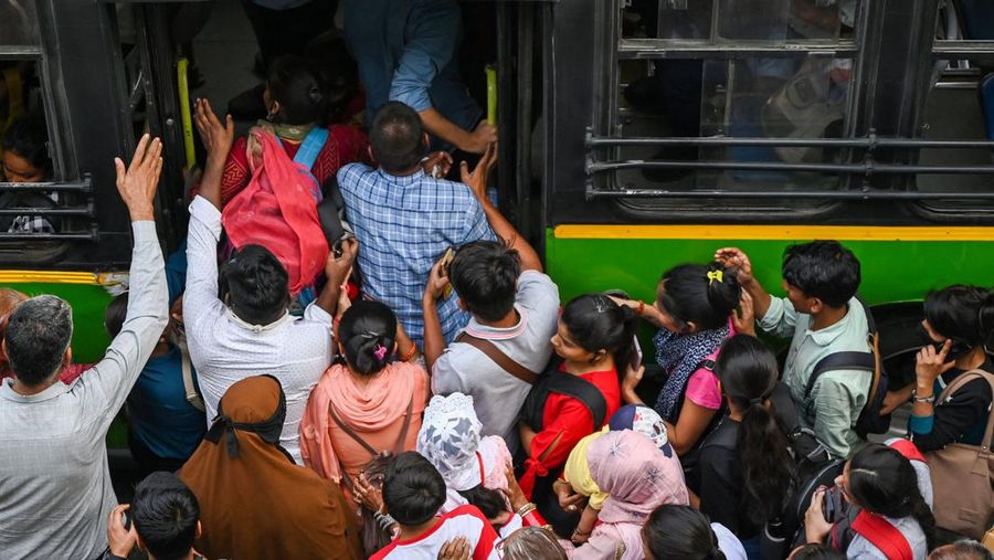 Orang-orang mengunjungi Gerbang India di New Delhi. - Setiap pagi dan sore dan selama beberapa jam di antara puluhan juta orang India duduk menganggur di jalan raya yang macet dan bergelantungan di sisi kereta penumpang yang padat di tempat yang menjadi negara terpadat di dunia. (Sajjad HUSSAIN / AFP)