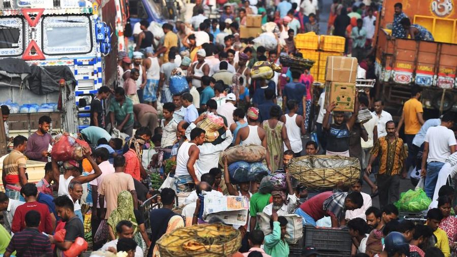 Orang-orang mengunjungi Gerbang India di New Delhi. - Setiap pagi dan sore dan selama beberapa jam di antara puluhan juta orang India duduk menganggur di jalan raya yang macet dan bergelantungan di sisi kereta penumpang yang padat di tempat yang menjadi negara terpadat di dunia. (Sajjad HUSSAIN / AFP)