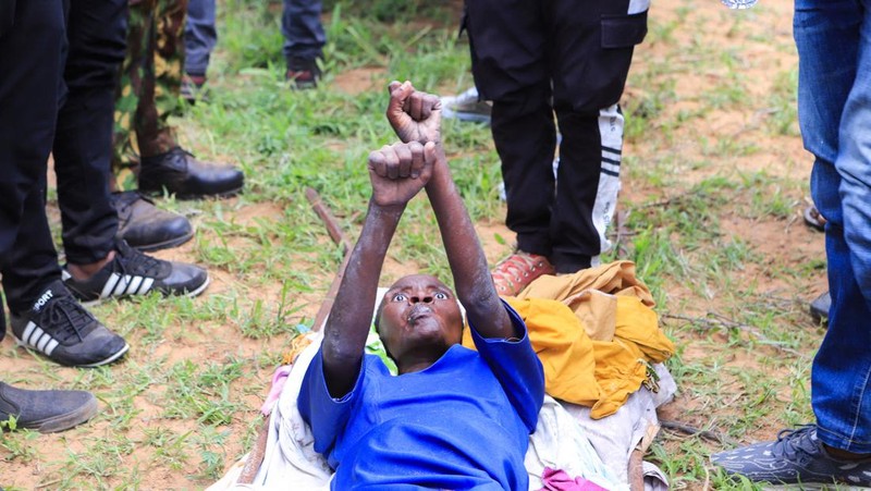 Steven Mwiti holds a photograph of his late wife Joan Bahati, a follower of a Christian cult named 