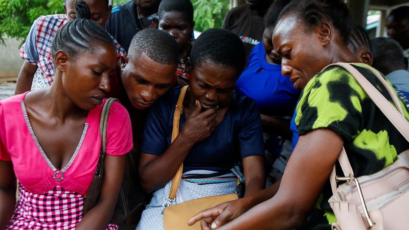 Steven Mwiti holds a photograph of his late wife Joan Bahati, a follower of a Christian cult named 