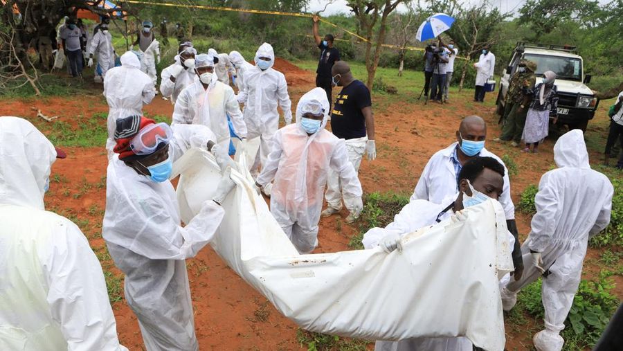 Forensic experts and homicide detectives carry the bodies of suspected members of a Christian cult named as Good News International Church, who believed they would go to heaven if they starved themselves to death, after their remains were exhumed from their graves in Shakahola forest of Kilifi county, Kenya April 22, 2023. REUTERS/Stringer