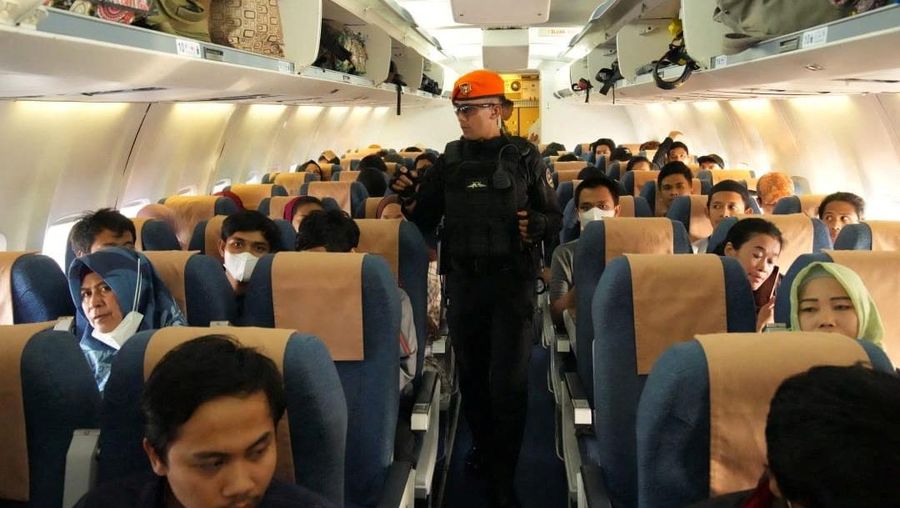 Indonesian citizens, who are evacuated from Sudan by a TNI task force, sit aboard a plane at an unknown location in this undated picture released April 27, 2023 and obtained from social media.  TNI Information Center via Facebook/via REUTERS  THIS IMAGE HAS BEEN SUPPLIED BY A THIRD PARTY. MANDATORY CREDIT. NO RESALES. NO ARCHIVES.