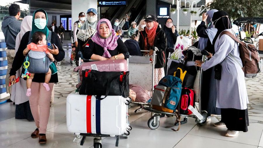 Seorang WNI yang dievakuasi dari Sudan duduk di dalam bus setelah dia tiba di Bandara Soekarno-Hatta di Tangerang, Banten, Jumat (28/4/2023). (REUTERS/AJENG DINAR ULFIANA)