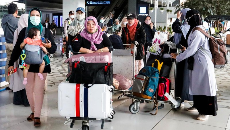Seorang WNI yang dievakuasi dari Sudan duduk di dalam bus setelah dia tiba di Bandara Soekarno-Hatta di Tangerang, Banten, Jumat (28/4/2023). (REUTERS/AJENG DINAR ULFIANA)