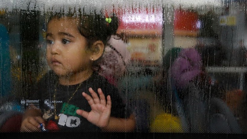 Seorang WNI yang dievakuasi dari Sudan duduk di dalam bus setelah dia tiba di Bandara Soekarno-Hatta di Tangerang, Banten, Jumat (28/4/2023). (REUTERS/AJENG DINAR ULFIANA)