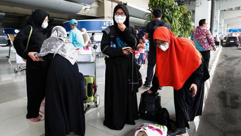 Seorang WNI yang dievakuasi dari Sudan duduk di dalam bus setelah dia tiba di Bandara Soekarno-Hatta di Tangerang, Banten, Jumat (28/4/2023). (REUTERS/AJENG DINAR ULFIANA)