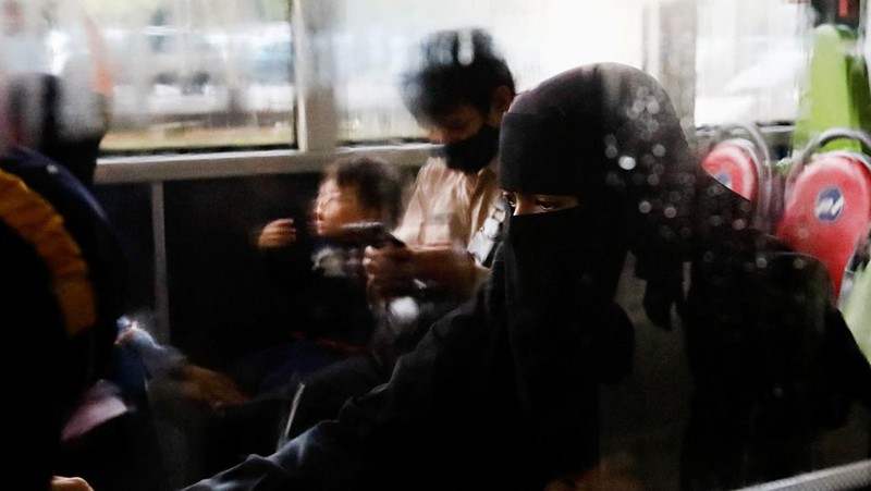 Seorang WNI yang dievakuasi dari Sudan duduk di dalam bus setelah dia tiba di Bandara Soekarno-Hatta di Tangerang, Banten, Jumat (28/4/2023). (REUTERS/AJENG DINAR ULFIANA)