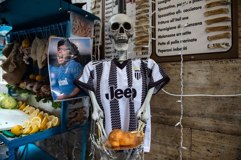 Bendera, spanduk, dan pita dipajang di jalan-jalan untuk merayakan kemenangan gelar Serie A ketiga pada 27 April 2023 di Naples, Italia. Kota Naples sedang bersiap untuk merayakan kemenangan Scudetto ketiga di kejuaraan Serie A. Di jalan-jalan pusat bersejarah dan di berbagai distrik Napoli, dekorasi, bendera, dan spanduk telah dipasang untuk merayakan kejuaraan sepak bola yang dimainkan oleh tim yang dilatih oleh Spalletti. Para pemain bisa menjadi juara Italia lebih awal, jika mereka berhasil mengalahkan Salernitana dalam derby Campania dalam pertandingan yang akan dimainkan pada hari Minggu pukul 15:00 di Stadion Diego Armando Maradona dan jika Lazio gagal menang tandang melawan Internazionale. Napoli telah memenangkan dua Scudetti dalam sejarahnya pada musim 1986-1987 dan 1989-1990, kedua kemenangan tersebut diperoleh dengan kehadiran Diego Armando Maradona, para fans Neapolitan menunggu untuk dapat merayakan 33 tahun setelah kesuksesan terakhir. (Ivan Romano/Getty Images)