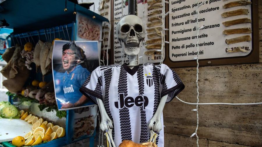 Bendera, spanduk, dan pita dipajang di jalan-jalan untuk merayakan kemenangan gelar Serie A ketiga pada 27 April 2023 di Naples, Italia. Kota Naples sedang bersiap untuk merayakan kemenangan Scudetto ketiga di kejuaraan Serie A. Di jalan-jalan pusat bersejarah dan di berbagai distrik Napoli, dekorasi, bendera, dan spanduk telah dipasang untuk merayakan kejuaraan sepak bola yang dimainkan oleh tim yang dilatih oleh Spalletti. Para pemain bisa menjadi juara Italia lebih awal, jika mereka berhasil mengalahkan Salernitana dalam derby Campania dalam pertandingan yang akan dimainkan pada hari Minggu pukul 15:00 di Stadion Diego Armando Maradona dan jika Lazio gagal menang tandang melawan Internazionale. Napoli telah memenangkan dua Scudetti dalam sejarahnya pada musim 1986-1987 dan 1989-1990, kedua kemenangan tersebut diperoleh dengan kehadiran Diego Armando Maradona, para fans Neapolitan menunggu untuk dapat merayakan 33 tahun setelah kesuksesan terakhir. (Ivan Romano/Getty Images)