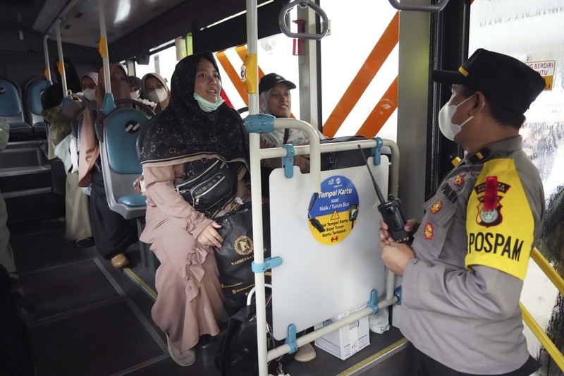 Seorang WNI yang dievakuasi dari Sudan duduk di dalam bus setelah dia tiba di Bandara Soekarno-Hatta di Tangerang, Banten, Jumat (28/4/2023). (REUTERS/AJENG DINAR ULFIANA)