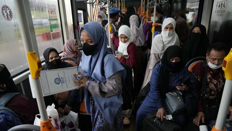 Seorang WNI yang dievakuasi dari Sudan duduk di dalam bus setelah dia tiba di Bandara Soekarno-Hatta di Tangerang, Banten, Jumat (28/4/2023). (REUTERS/AJENG DINAR ULFIANA)