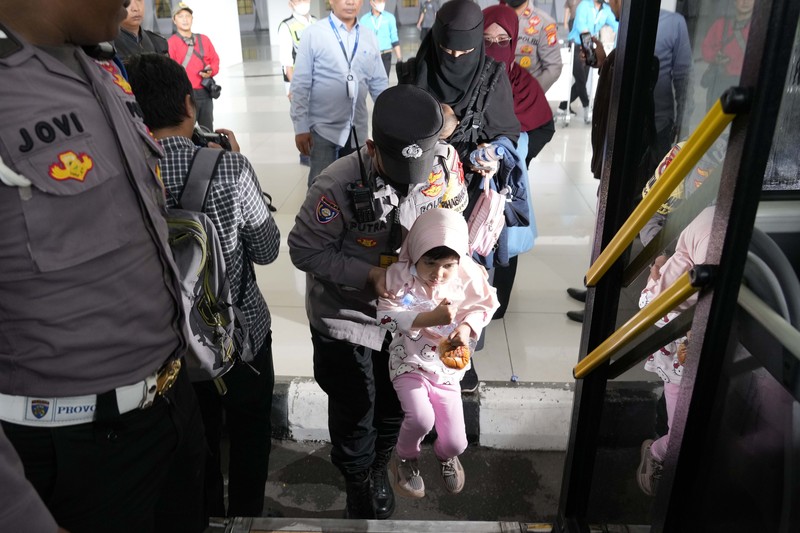 Seorang WNI yang dievakuasi dari Sudan duduk di dalam bus setelah dia tiba di Bandara Soekarno-Hatta di Tangerang, Banten, Jumat (28/4/2023). (REUTERS/AJENG DINAR ULFIANA)