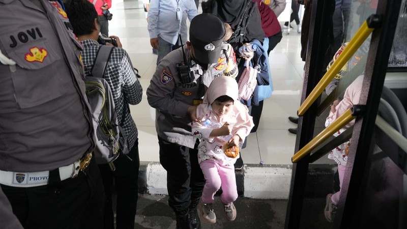 Seorang WNI yang dievakuasi dari Sudan duduk di dalam bus setelah dia tiba di Bandara Soekarno-Hatta di Tangerang, Banten, Jumat (28/4/2023). (REUTERS/AJENG DINAR ULFIANA)