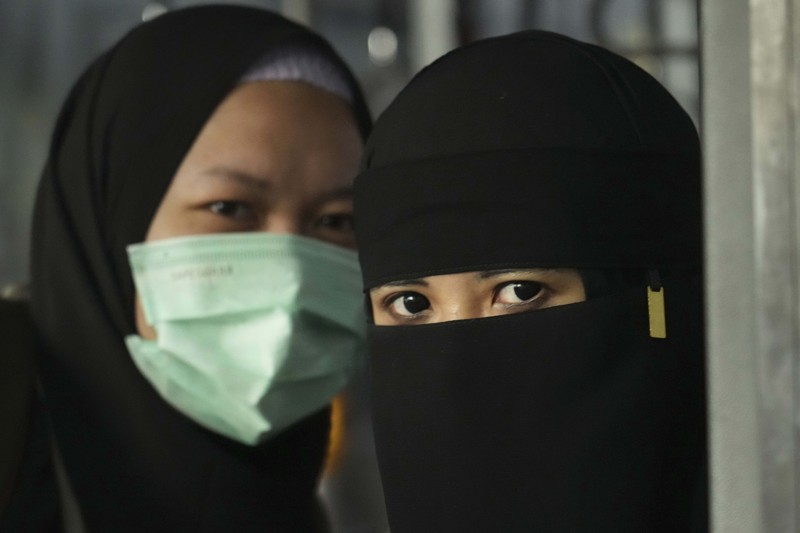 Seorang WNI yang dievakuasi dari Sudan duduk di dalam bus setelah dia tiba di Bandara Soekarno-Hatta di Tangerang, Banten, Jumat (28/4/2023). (REUTERS/AJENG DINAR ULFIANA)