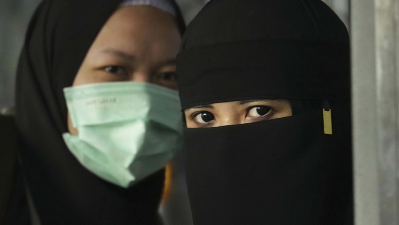 Seorang WNI yang dievakuasi dari Sudan duduk di dalam bus setelah dia tiba di Bandara Soekarno-Hatta di Tangerang, Banten, Jumat (28/4/2023). (REUTERS/AJENG DINAR ULFIANA)