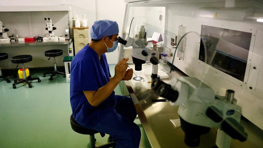 Anggota staf berjalan melewati ruang tunggu pusat reproduksi berbantuan di Rumah Sakit Keluarga Sempurna Beijing, yang berspesialisasi dalam perawatan kesuburan, di Beijing, China 6 April 2023. (REUTERS/Tingshu Wang)