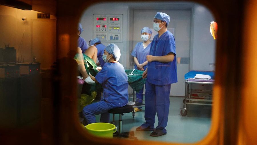 Dokter Xu Xiaoming, direktur laboratorium embriologi dari pusat reproduksi berbantuan, berpartisipasi dalam operasi transfer embrio, di Rumah Sakit Keluarga Sempurna Beijing, yang berspesialisasi dalam perawatan kesuburan, di Beijing, Tiongkok, 6 April 2023. (REUTERS/Tingshu Wang)
