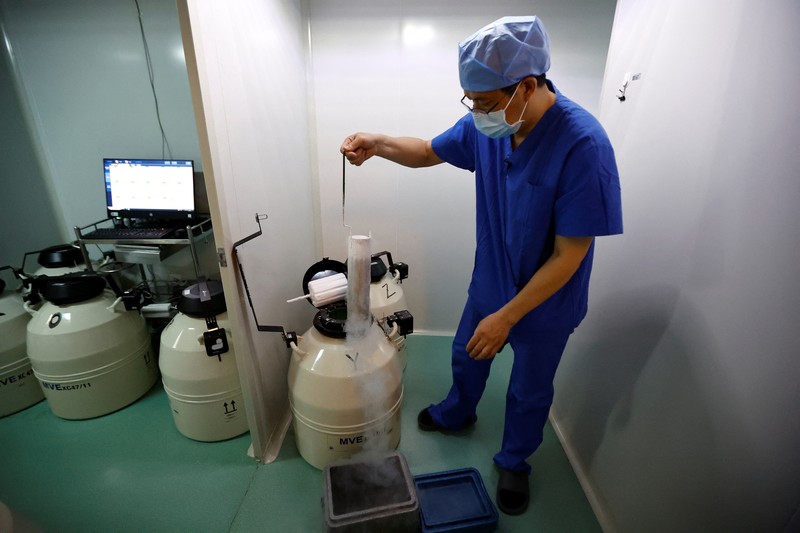 Anggota staf berjalan melewati ruang tunggu pusat reproduksi berbantuan di Rumah Sakit Keluarga Sempurna Beijing, yang berspesialisasi dalam perawatan kesuburan, di Beijing, China 6 April 2023. (REUTERS/Tingshu Wang)