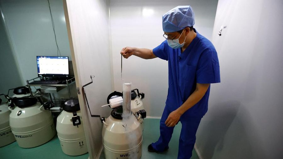 Anggota staf berjalan melewati ruang tunggu pusat reproduksi berbantuan di Rumah Sakit Keluarga Sempurna Beijing, yang berspesialisasi dalam perawatan kesuburan, di Beijing, China 6 April 2023. (REUTERS/Tingshu Wang)