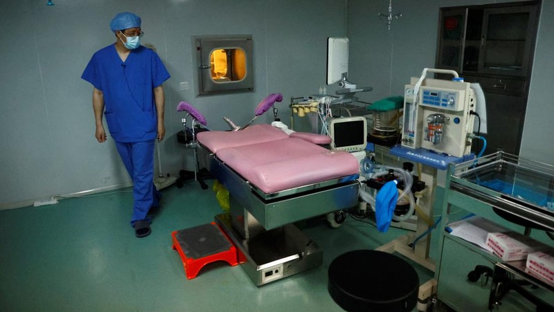 Anggota staf berjalan melewati ruang tunggu pusat reproduksi berbantuan di Rumah Sakit Keluarga Sempurna Beijing, yang berspesialisasi dalam perawatan kesuburan, di Beijing, China 6 April 2023. (REUTERS/Tingshu Wang)