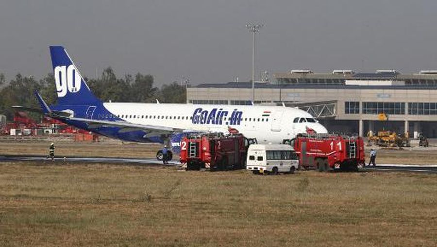 Firefighter vehicles and an ambulance are seen next to a Go Air plane after fiefighters douse a small fire in its right engine at Ahmedabad Airport on February 18, 2020. (Photo by AFP)