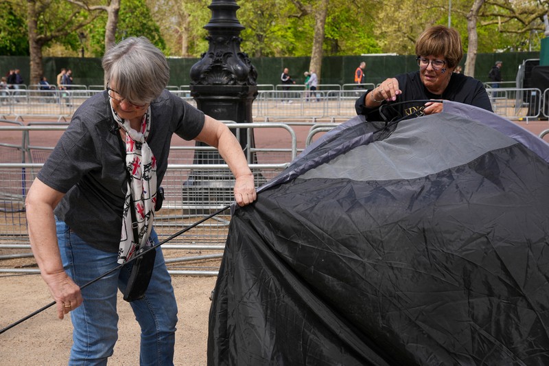 Penggemar kerajaan Inggris, Mary-Jane Willows dari Inggris dan Donna Werner dari AS berjalan ke The Mall untuk mendirikan kemah jelang Penobatan Raja Charles, di London, Inggris, Selasa (2/5/2023). REUTERS/Maja Smiejkowska