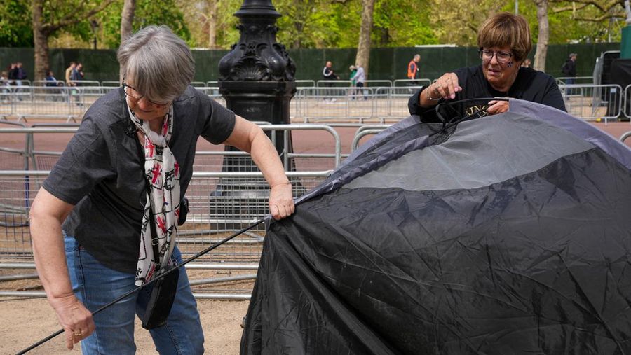 Penggemar kerajaan Inggris, Mary-Jane Willows dari Inggris dan Donna Werner dari AS berjalan ke The Mall untuk mendirikan kemah jelang Penobatan Raja Charles, di London, Inggris, Selasa (2/5/2023). REUTERS/Maja Smiejkowska
