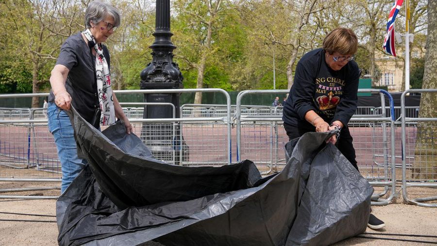 Penggemar kerajaan Inggris, Mary-Jane Willows dari Inggris dan Donna Werner dari AS berjalan ke The Mall untuk mendirikan kemah jelang Penobatan Raja Charles, di London, Inggris, Selasa (2/5/2023). REUTERS/Maja Smiejkowska