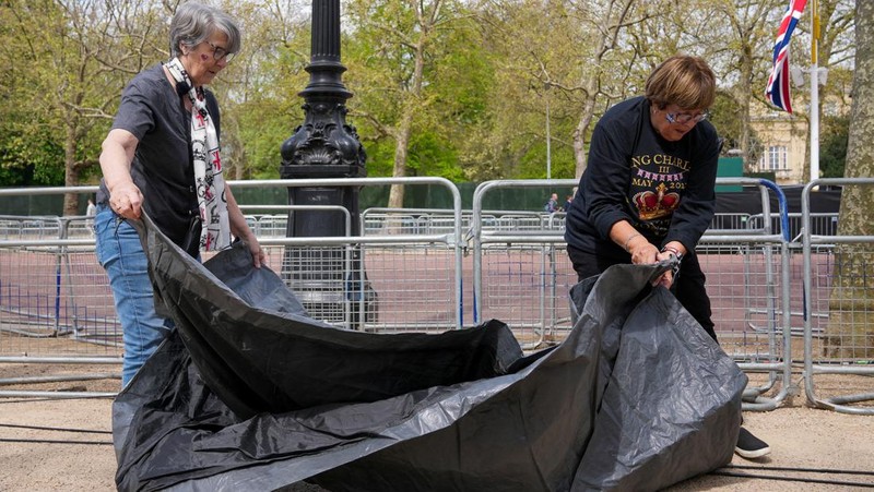 Penggemar kerajaan Inggris, Mary-Jane Willows dari Inggris dan Donna Werner dari AS berjalan ke The Mall untuk mendirikan kemah jelang Penobatan Raja Charles, di London, Inggris, Selasa (2/5/2023). REUTERS/Maja Smiejkowska