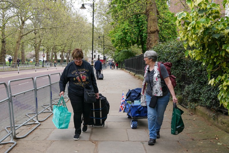 Penggemar kerajaan Inggris, Mary-Jane Willows dari Inggris dan Donna Werner dari AS berjalan ke The Mall untuk mendirikan kemah jelang Penobatan Raja Charles, di London, Inggris, Selasa (2/5/2023). Penggemar kerajaan Inggris, Mary-Jane Willows dari Inggris dan Donna Werner dari AS berjalan ke The Mall untuk mendirikan kemah jelang Penobatan Raja Charles, di London, Inggris, Selasa (2/5/2023). REUTERS/Maja Smiejkowska