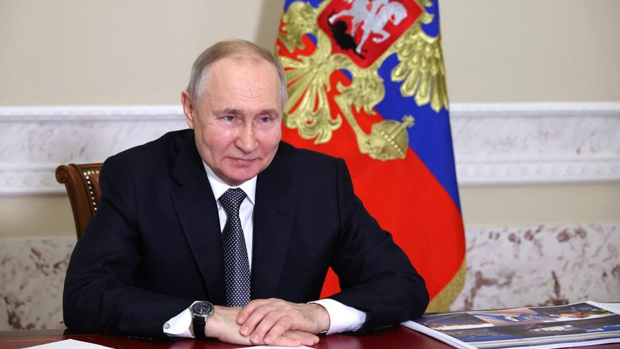 Presiden Rusia Vladimir Putin menghadiri upacara untuk melanjutkan operasi trem di kota pelabuhan Laut Azov Mariupol di wilayah Donetsk yang dikuasai Rusia, melalui tautan video dari Saint Petersburg pada 2 Mei 2023. (MIKHAIL KLIMENTYEV/SPUTNIK/AFP via Getty Images)