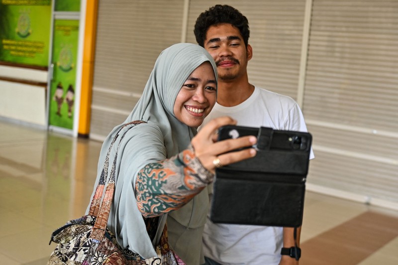 Seorang kerabat memeluk seorang pria (R), bagian dari sekelompok mahasiswa Indonesia yang dievakuasi dari Sudan yang dilanda konflik, setelah kedatangannya di Bandara Internasional Sultan Iskandar Muda di Blang Bintang, Provinsi Aceh pada 2 Mei 2023. Seorang kerabat memeluk seorang pria (R), bagian dari sekelompok mahasiswa Indonesia yang dievakuasi dari Sudan yang dilanda konflik, setelah kedatangannya di Bandara Internasional Sultan Iskandar Muda di Blang Bintang, Provinsi Aceh pada 2 Mei 2023. - Sejak pertempuran pecah pada tanggal 15 April, beberapa pemerintah asing dari seluruh penjuru dunia telah mengorganisir konvoi jalan, pesawat terbang dan kapal untuk membawa ribuan warga negara mereka keluar dari Sudan, dan warga telah melarikan diri melalui darat ke negara tetangga. (CHAIDEER MAHYUDDIN/AFP via Getty Images)