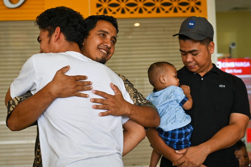 Seorang kerabat memeluk seorang pria (R), bagian dari sekelompok mahasiswa Indonesia yang dievakuasi dari Sudan yang dilanda konflik, setelah kedatangannya di Bandara Internasional Sultan Iskandar Muda di Blang Bintang, Provinsi Aceh pada 2 Mei 2023. - Sejak pertempuran pecah pada tanggal 15 April, beberapa pemerintah asing dari seluruh penjuru dunia telah mengorganisir konvoi jalan, pesawat terbang dan kapal untuk membawa ribuan warga negara mereka keluar dari Sudan, dan warga telah melarikan diri melalui darat ke negara tetangga. (CHAIDEER MAHYUDDIN/AFP via Getty Images)