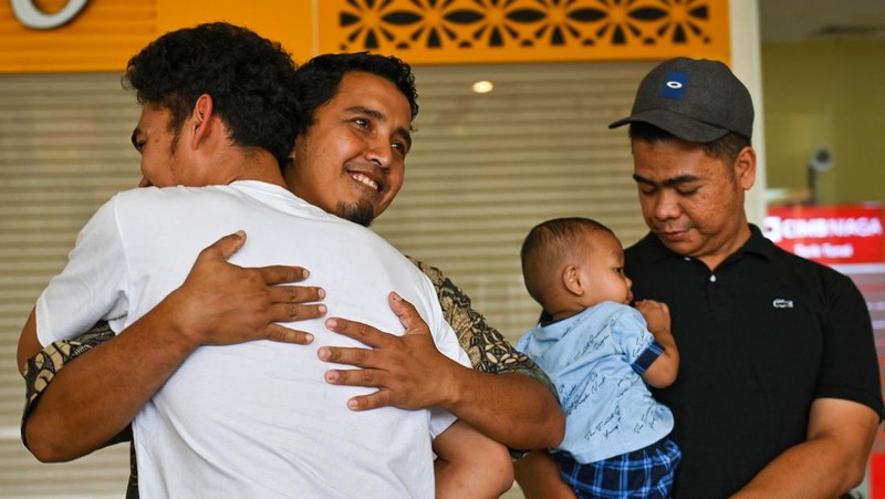 Seorang kerabat memeluk seorang pria (R), bagian dari sekelompok mahasiswa Indonesia yang dievakuasi dari Sudan yang dilanda konflik, setelah kedatangannya di Bandara Internasional Sultan Iskandar Muda di Blang Bintang, Provinsi Aceh pada 2 Mei 2023. - Sejak pertempuran pecah pada tanggal 15 April, beberapa pemerintah asing dari seluruh penjuru dunia telah mengorganisir konvoi jalan, pesawat terbang dan kapal untuk membawa ribuan warga negara mereka keluar dari Sudan, dan warga telah melarikan diri melalui darat ke negara tetangga. (CHAIDEER MAHYUDDIN/AFP via Getty Images)