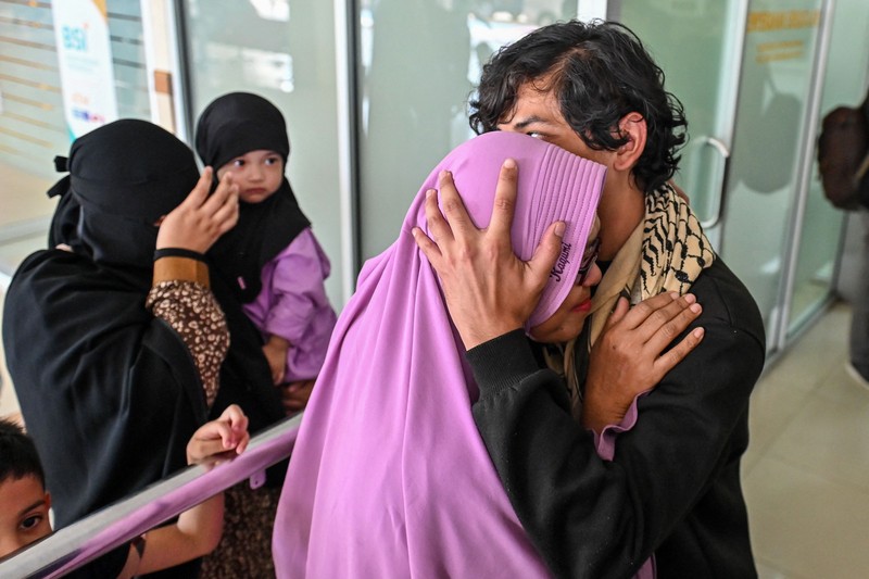 Seorang kerabat memeluk seorang pria (R), bagian dari sekelompok mahasiswa Indonesia yang dievakuasi dari Sudan yang dilanda konflik, setelah kedatangannya di Bandara Internasional Sultan Iskandar Muda di Blang Bintang, Provinsi Aceh pada 2 Mei 2023. - Sejak pertempuran pecah pada tanggal 15 April, beberapa pemerintah asing dari seluruh penjuru dunia telah mengorganisir konvoi jalan, pesawat terbang dan kapal untuk membawa ribuan warga negara mereka keluar dari Sudan, dan warga telah melarikan diri melalui darat ke negara tetangga. (CHAIDEER MAHYUDDIN/AFP via Getty Images)