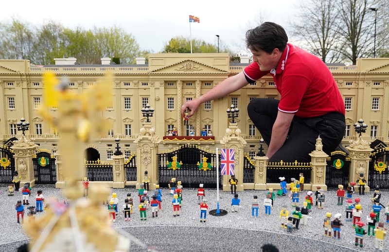 Daniel Anderson
menyelesaikan pembuatan miniatur adegan penobatan Raja Charles III dan Ratu Camilia di balkon Istana Buckingham, London, Inggris, Rabu (26/4/2023). (PA Images via Getty Images)