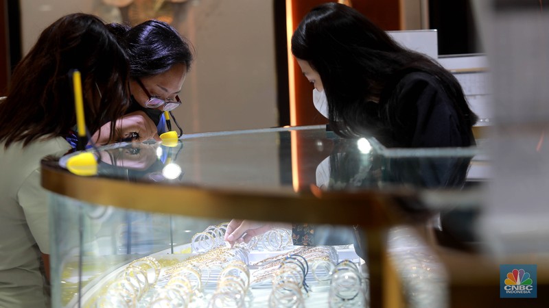 Karyawati menunjukkan emas PT Aneka Tambang Tbk. (Antam) di salah satu gallery penjualan emas di Jakarta, Kamis (4/5). (CNBC Indonesia/Muhammad Sabki)